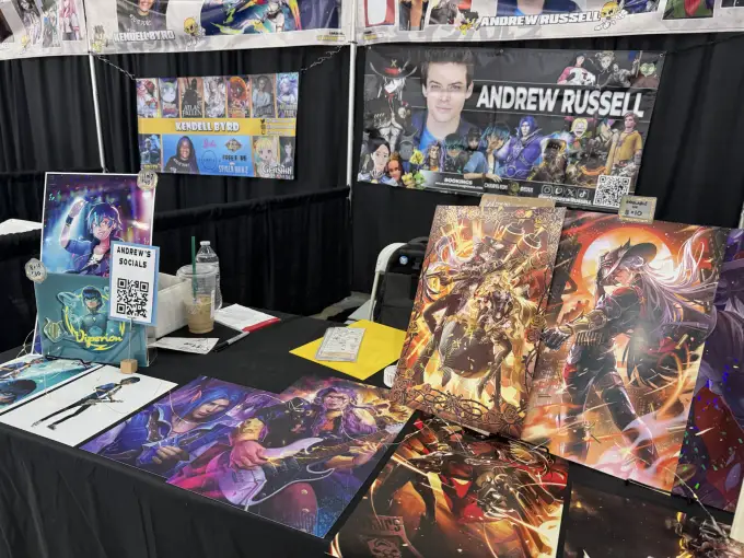 Andrew Russell convention table with character prints and signing materials