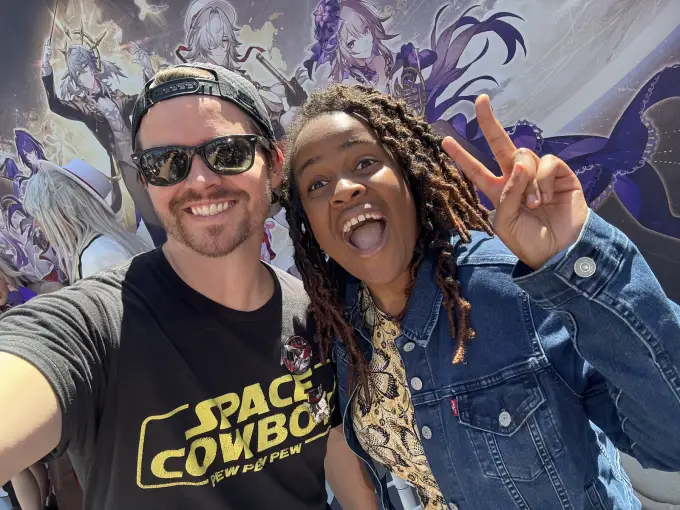 Andrew Russell taking a bright convention-floor selfie with a fan