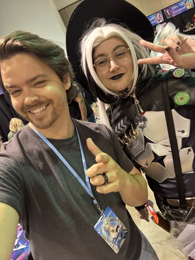 Andrew Russell posing with a cosplayer at a convention