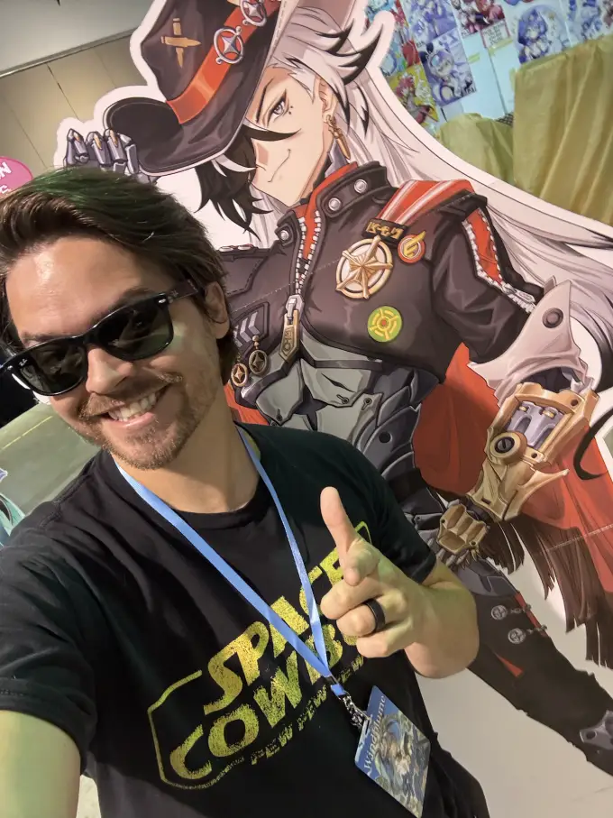 Andrew Russell at a fan event with character displays behind him