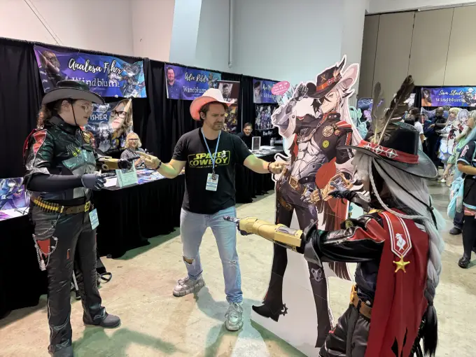 Andrew Russell interacting with a group of cosplayers on the convention floor