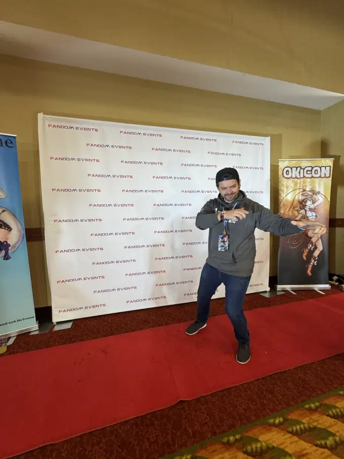 Andrew Russell having fun at a convention step-and-repeat