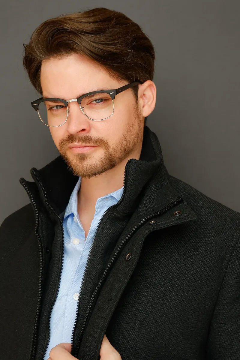 Andrew Russell additional dramatic headshot in glasses and a black jacket
